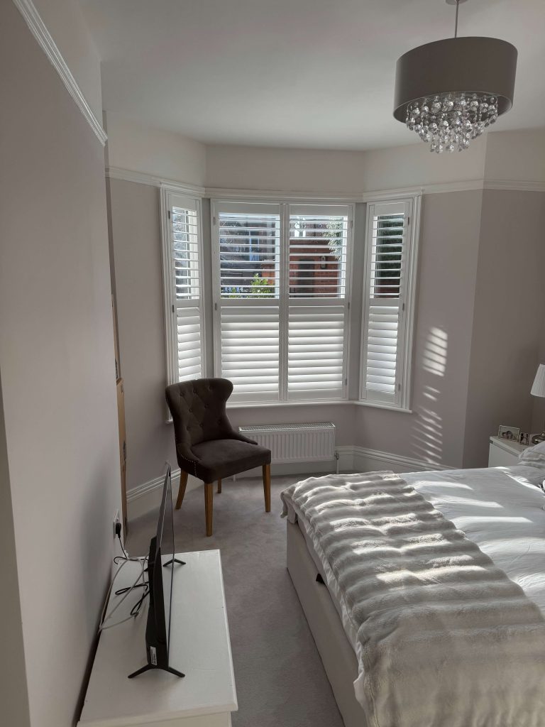 Made-to-measure white plantation shutters fitted to a bay window